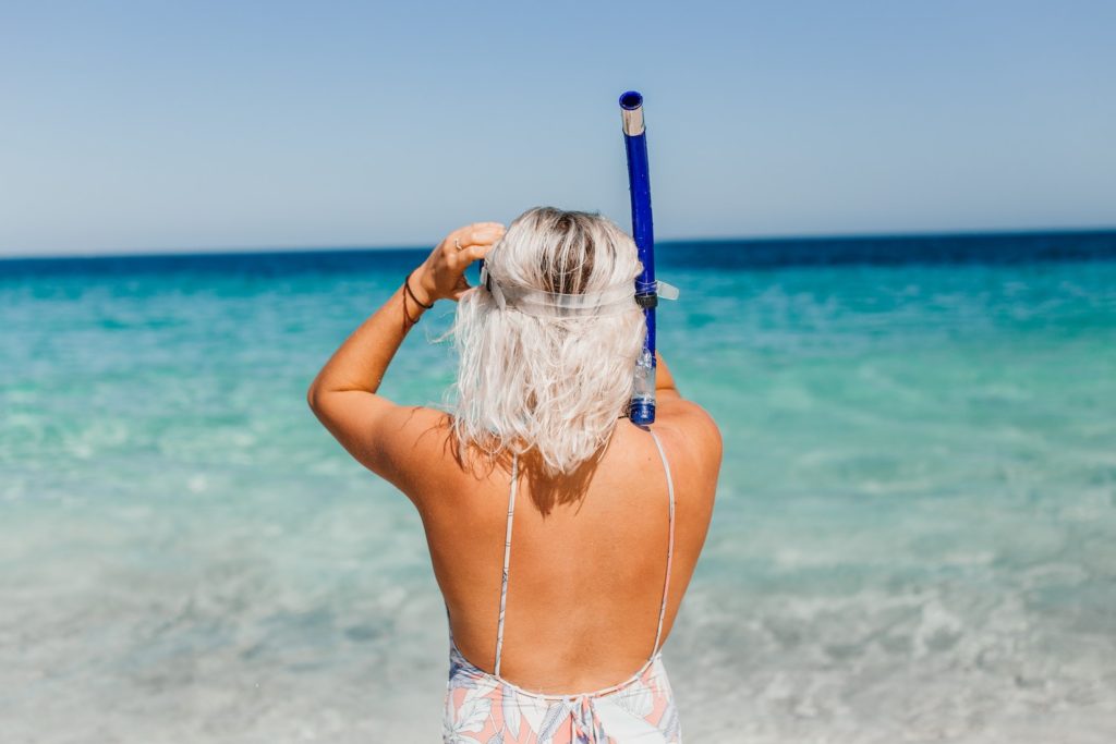 Woman Getting Ready To Snorkel From Beach