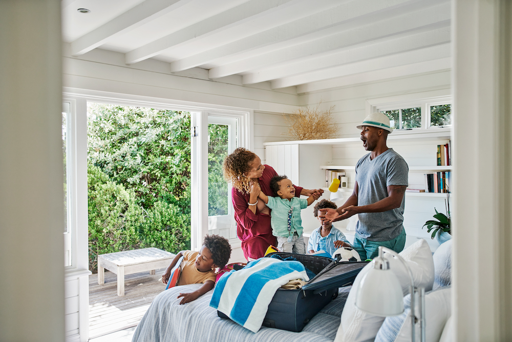 family on vacation standing in bedroom of vacation rental at beach